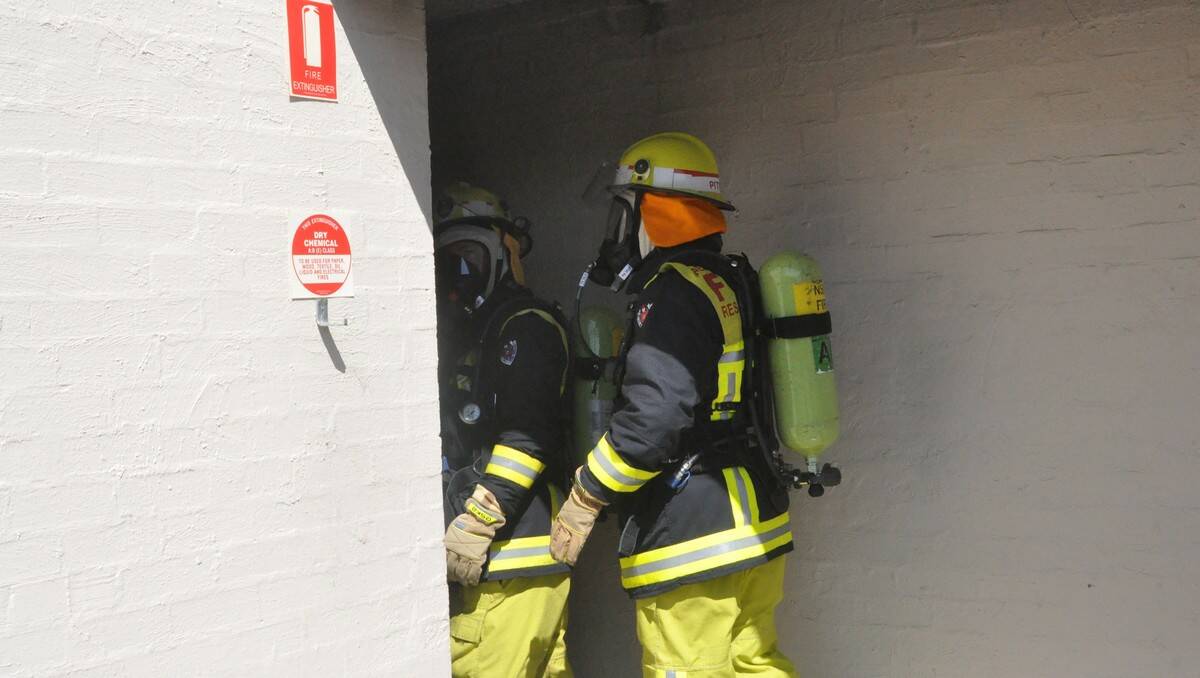 Batemans Bay Fire and Rescue crew inspect the damage a fire caused in the motel's laundry room.