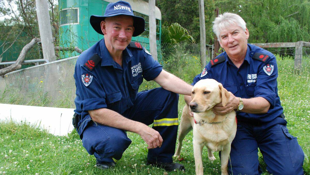 THANKS GUYS: Honey Bun the Labrador is reunited with two of her rescuers from last Friday - retained firefighter Russell Allen and deputy captain Alan Fitches of Batemans Bay Fire and Rescue.