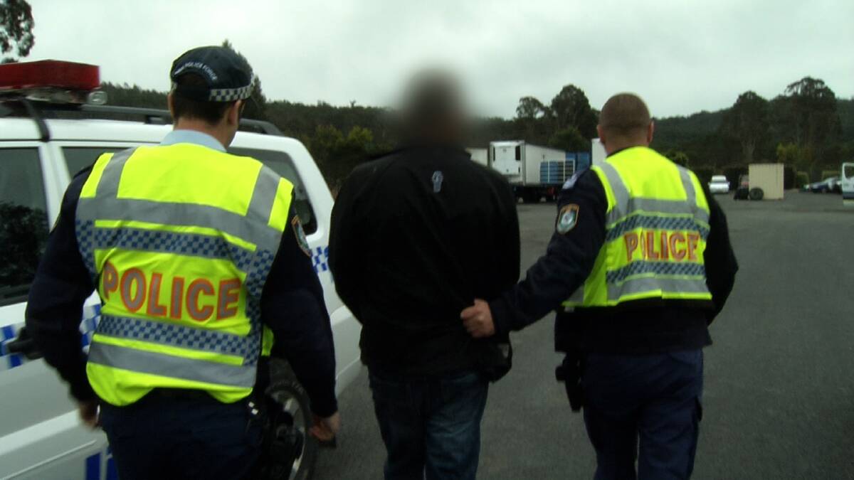 Brendon Bobbin is led away after being arrested at South Coast Bobbins depot on Thursday. With him are Eden police officers Constable Andrew Kuzmins and Sergeant Scott Blanch (right).
