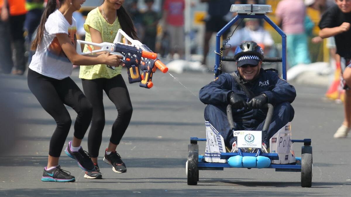 OAK FLATS: Senior Constable Scott Burgess came under attach from a couple of random girls and their water pistols at Sunday's Oak Flats   Billy Cart Derby.
