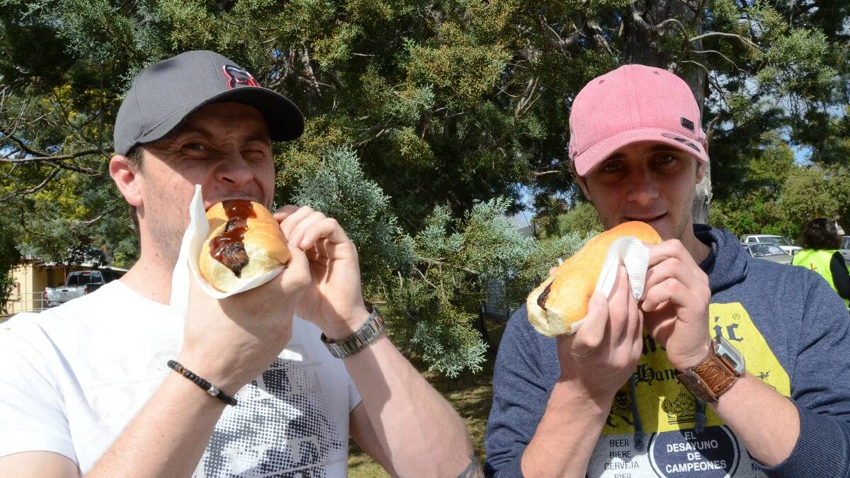Cootamundra’s Jason and Derek Krogh tuck in to their sausage sangas at the Moruya Public School polling booth.