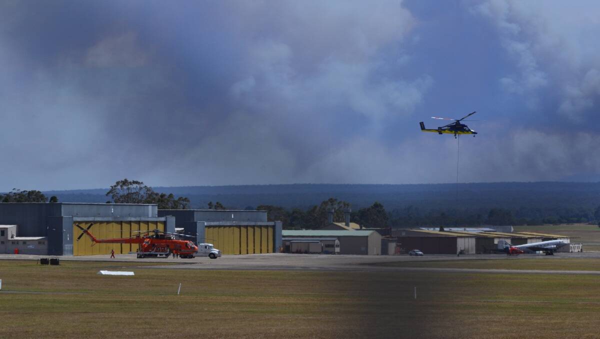 A water bombing helicopter leaves from HMAS Albatross west of Nowra to assist with the battle against the fire at Deans Gap which broke containment lines yesterday afternoon. Photo by Adam Wright  