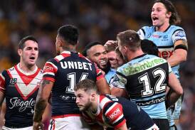 Nicho Hynes (right) celebrates one of six Cronulla tries in the high-scoring win over the Roosters. (Dave Hunt/AAP PHOTOS)