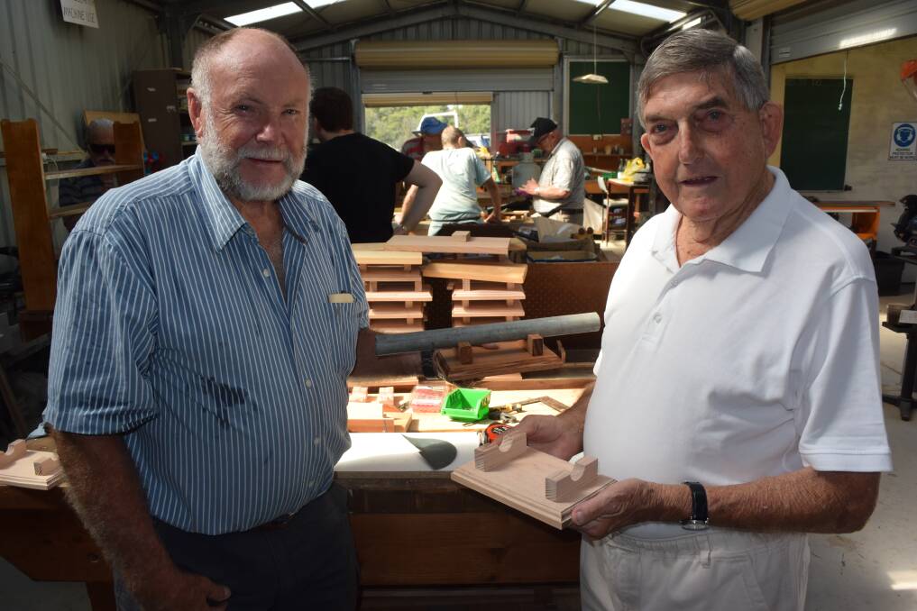 (L-R): Batemans Bay Mens Shed life members Neil Page and George Fitzgerald with the makings of a plaque presented to the families and descendants of fallen soldiers on Anzac Day 2015. Photo: Josh Gidney