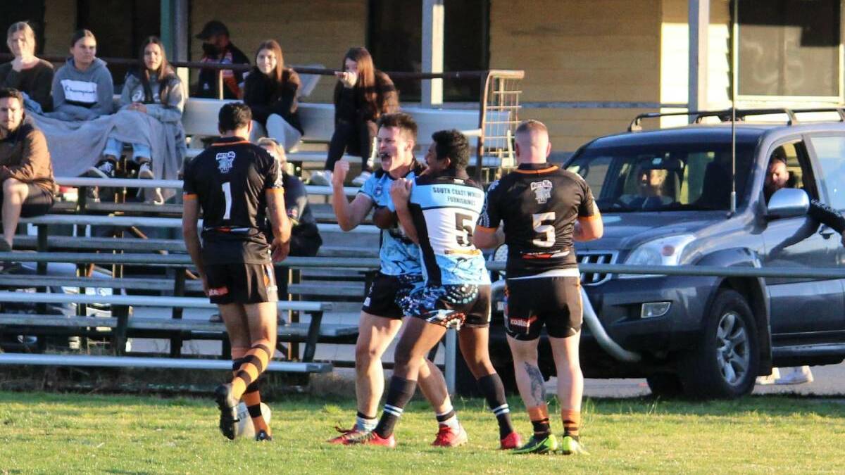 Jack Grant and Yuin Campbell celebrate a try during a match between the Tigers and Sharks in 2021.
