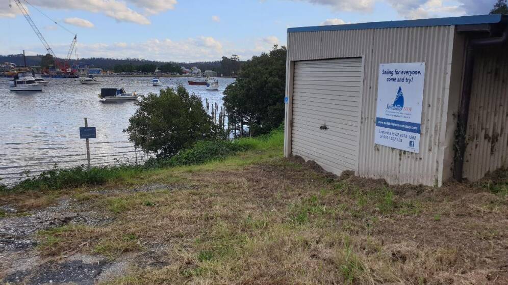 A shed near the proposed jetty site where Batemans Bay Sailability signage can already be seen.
