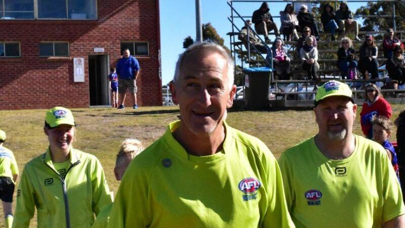 Ash Lamb (front) has been acknowledged for his volunteer work as an umpire and umpire's coordinator with the Sapphire Coast AFL.