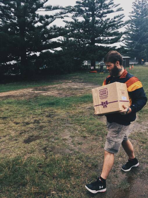 The Family Place's Joel Ryan delivering an essential box of food from food bank in the pouring rain.
Picture: James Tugwell