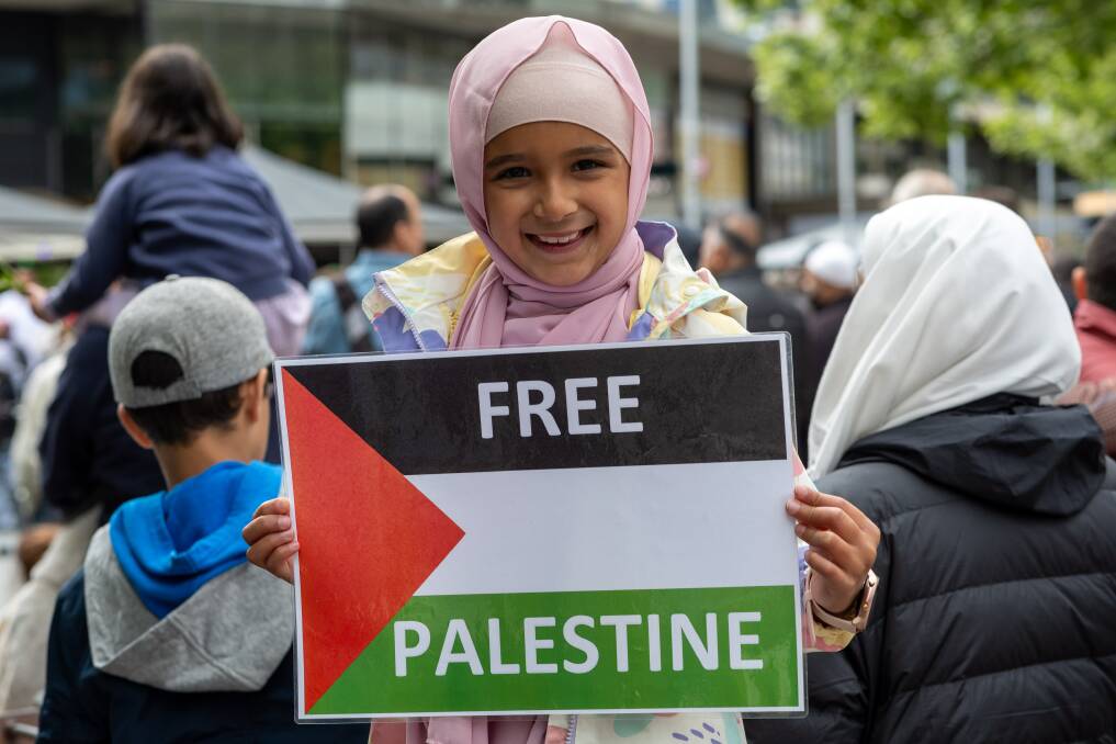 Protesters at a pro-Palestine rally in Canberra's Garema Place on October 13. A young girl holds a 'Free Palestine' sign. Picture By Gary Ramage