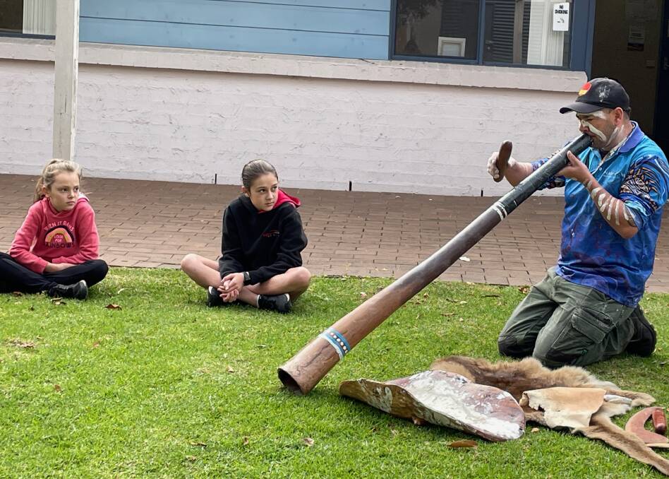 At Narooma Library's NAIDOC cultural workshop Nigel Stewart played the didgeridoo after showing some traditional resources including the world's oldest cradle (the coolamon to the right of the didgeridoo). Picture by Marion Williams.