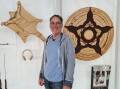 Nick Hopkins between two of his works 'Greater Glider' and 'Pentacle Mandala' on exhibition at Sculpture for Clyde. Picture supplied.