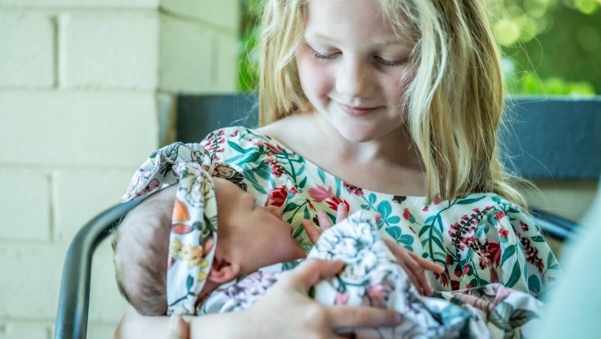 Big sister Scarlett, six, holding Ivy. Picture by Karleen Minney 