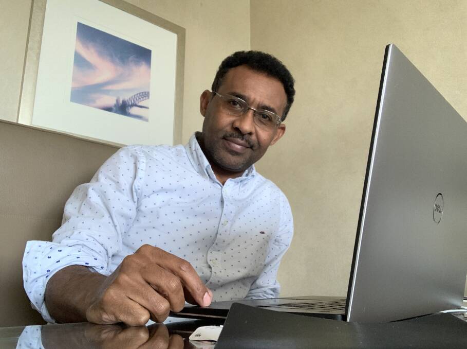 Dr Yohannes Kinfu working inside his hotel room in Sydney. Picture: Supplied