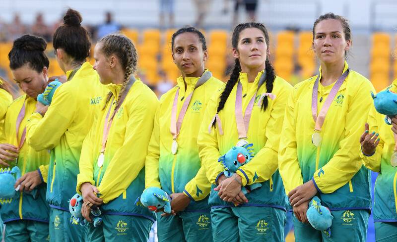 BIG DAY: An exhausted Cassie Staples (looking at camera) on the podium after the Australian Rugby Sevens women's side won silver at the Commonwealth Games.