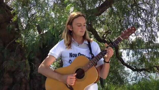 SONG FOR CHANGE: Sam Fletcher plays in Moruya on Monday. Picture taken from Gillianne Tedder's video.