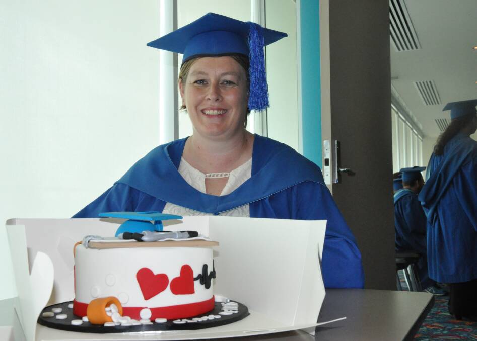 REASON TO CELEBRATE: New nurse Sarah Carpenter has more than enough skills to take a scalpel to this cake after graduating yesterday.