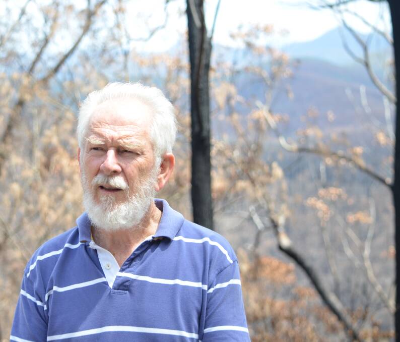 DEUA DAYS: Peter Cormick on Larrys Mountain Road on February 14 with his beloved but burned Deua Valley in the background. He and wife Anne lost all their riverside buildings, but plan to rebuild with shipping containers.