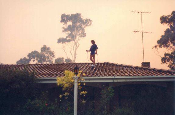 An unknown person hoses the Learmont house in Denhams Beach in 1994. Do you know who this was? Picture: Joan Learmont 
