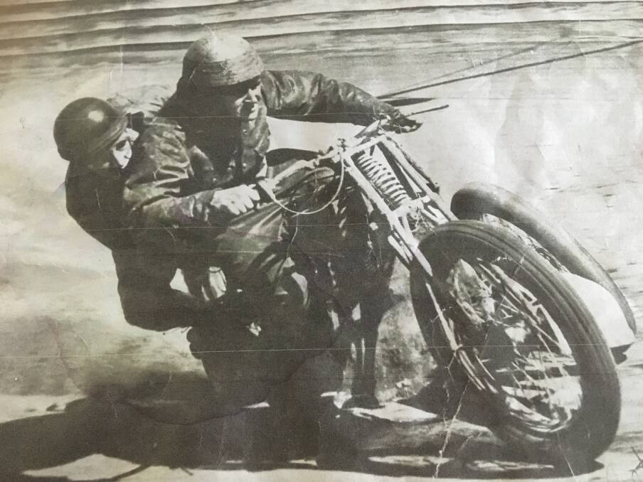 IN THE SWING: Ray Rogers swinging out on the back of a motor cycle in a race at Sydney Showground.