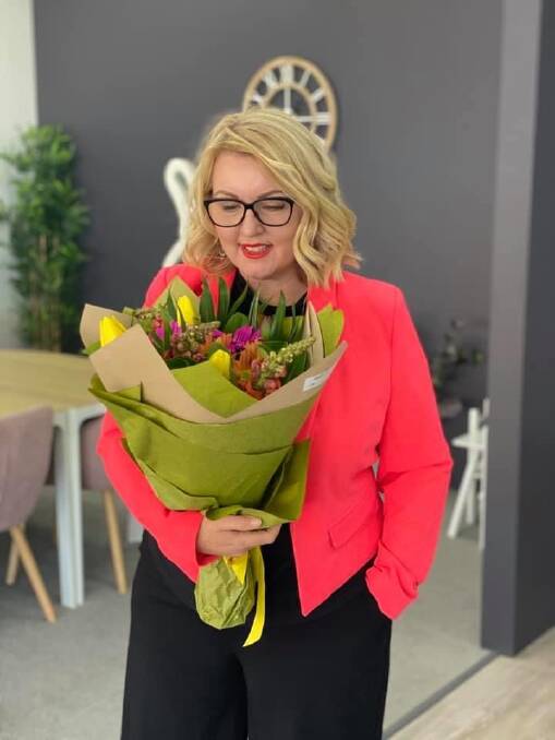 Fashionista: Real Estate agent Christine Ewin was looking gorgeous with flowers from a grateful client. Christine says real estate is open for business.