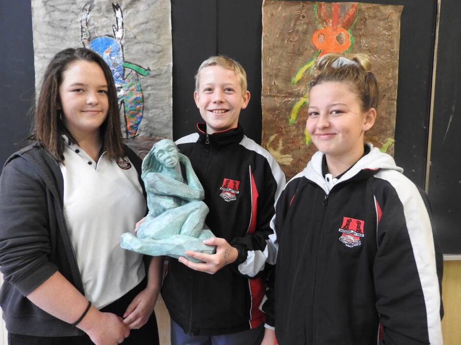Batemans Bay High School students Italia Quinlivan, Dylan Hill and Mia Bryce-Glen with the Susan McAlister sculpture "Firefly" which was presented to the school last year and now has pride of place for students to enjoy.