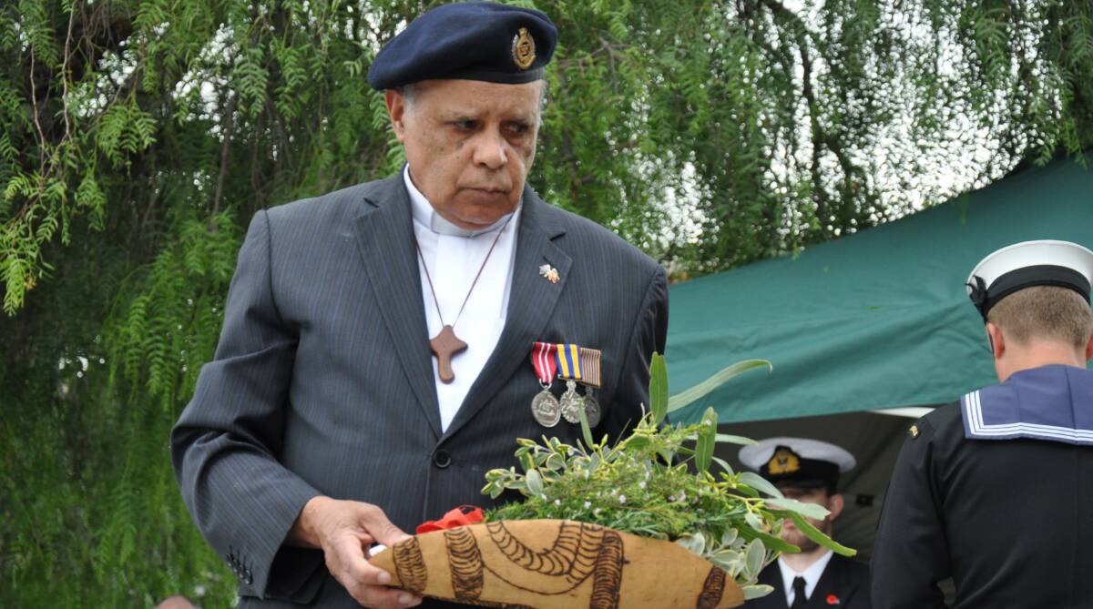 The Reverend Tom Slockee lays flowers for Indigenous service people, at the Batemans Bay Anzac Day service on Tuesday, April 25, 2017.