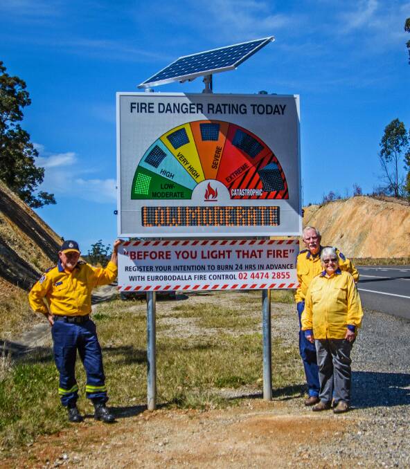 COLOURFUL CREW: Malua Bay Rural Fire Service members Graeme Skelton and Dave and Christine Beare with their new warning sign.