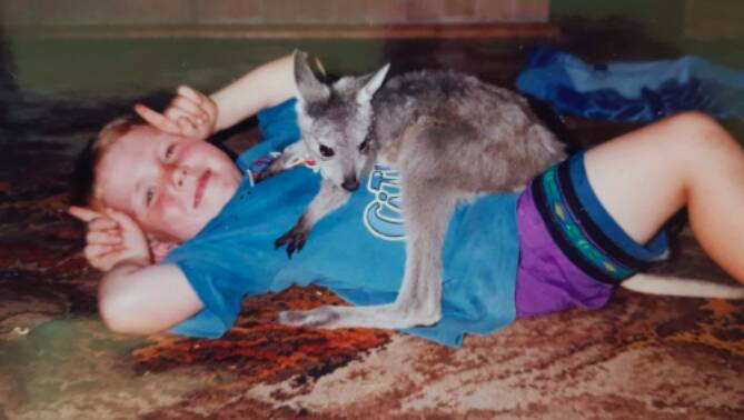Andrew Drake as a child, with a joey named Drew.
