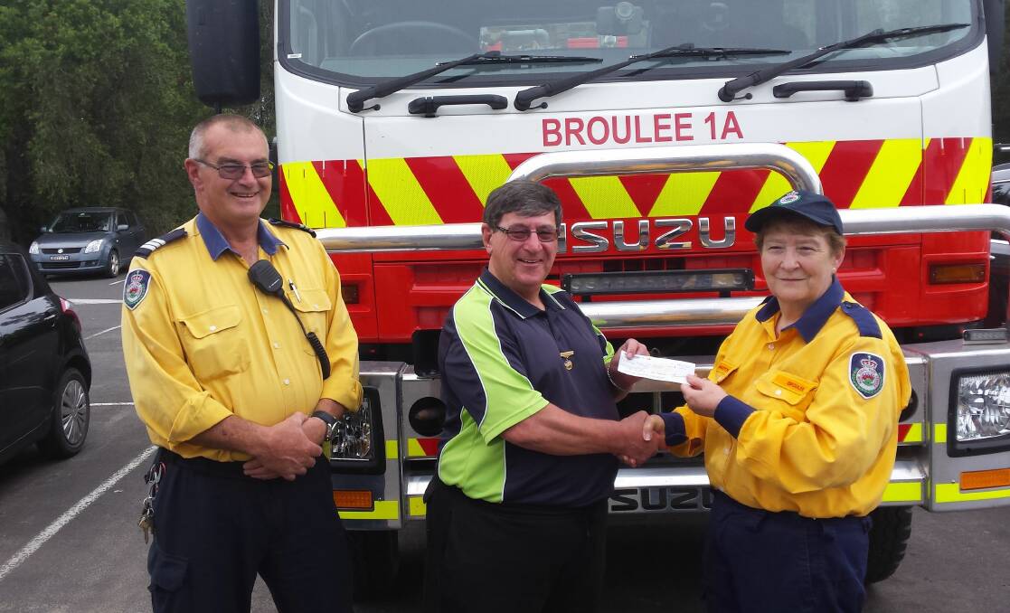 TOMAKIN MEN: Broulee Bush Fire Brigade President Charlotte O'Grady receives donation from president Gary Chapman.