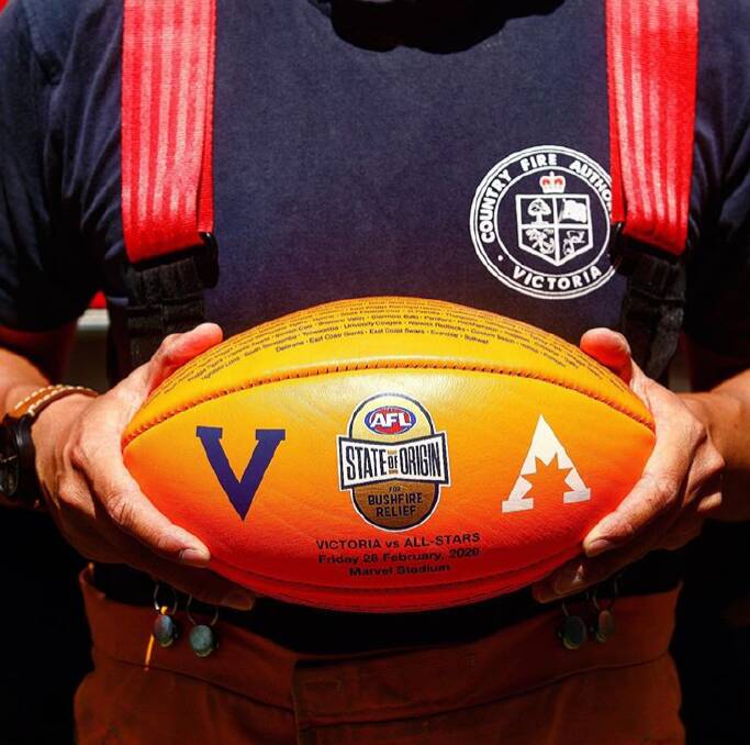 A Victorian firefighter holds one of the custom-made Sherrins for Friday's State of Origin match. Photo: AFL MEDIA
