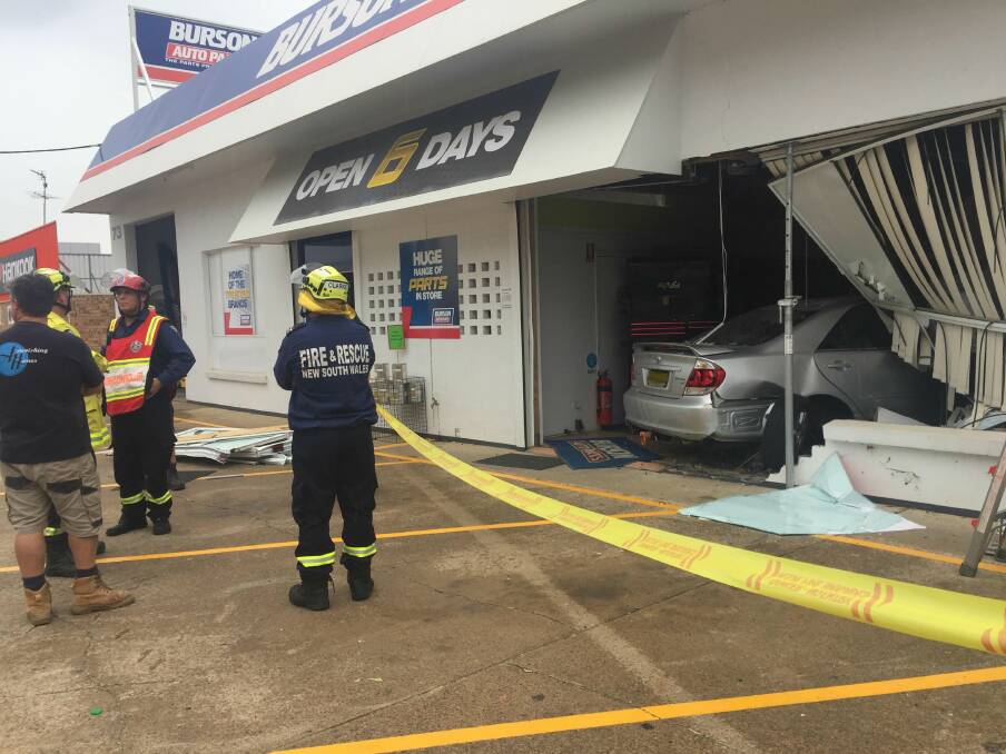 At 10am, rescue crews work to remove a vehicle from inside an auto parts shop in Batemans Bay, Friday, March 29. 