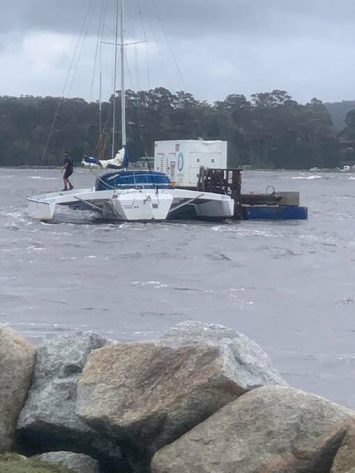 A trimaran and a barge drifting towards sea in the Clyde River, Batemans Bay on Monday, February 10. Picture: Supplied. 