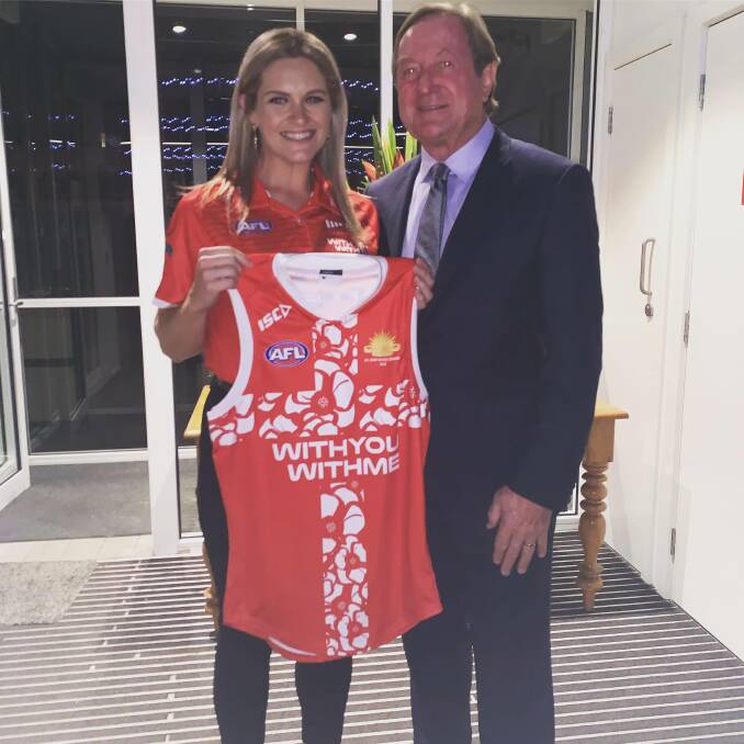 Kirby Mackie accepts her new jumper next to Kevin Sheedy, former coach of Essendon Bombers.