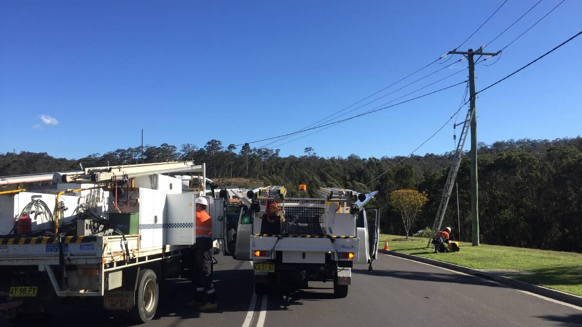 Essential Energy crews climb the power pole to fix live wires at Cranbrook Road, Batemans Bay on October 17.