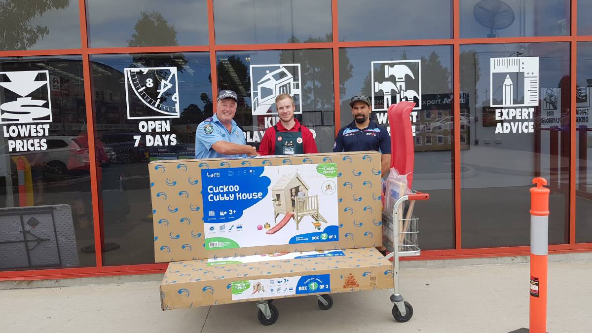 Nigel Bell of Batemans Bay Bunnings donates a flat pack cubby house to Senior Constable Greg Curry with PCYC Youth Worker Caine Brierley.