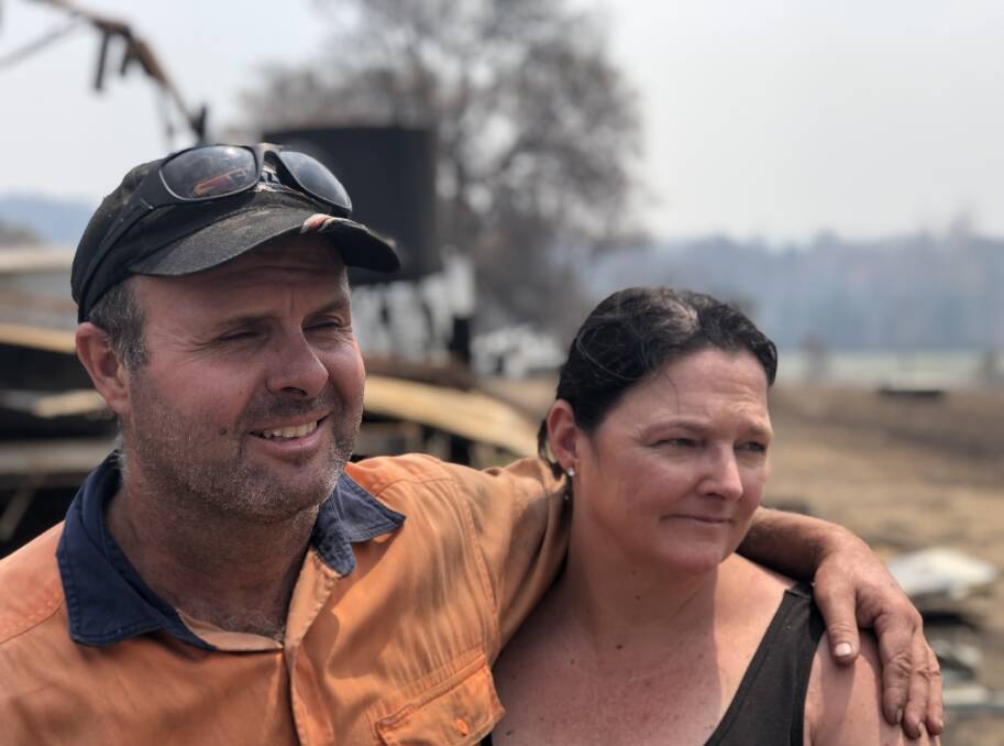 DETERMINED: Without power for two weeks, Guy and Caroline McPhee say they will rebuild their little corner of paradise. Photo: John Hanscombe
