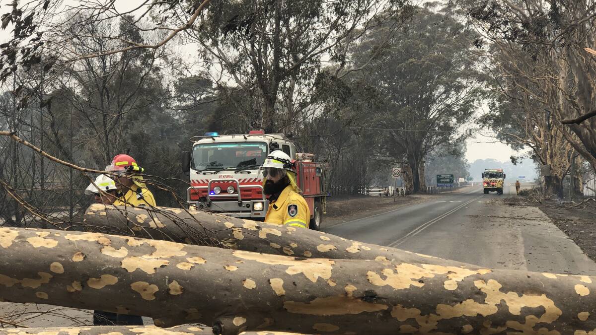 RFS volunteers prepare to remove a tree across a road during the Black Summer fires. Email your photos to community.eurobodalla@austcommunitymedia.com.au