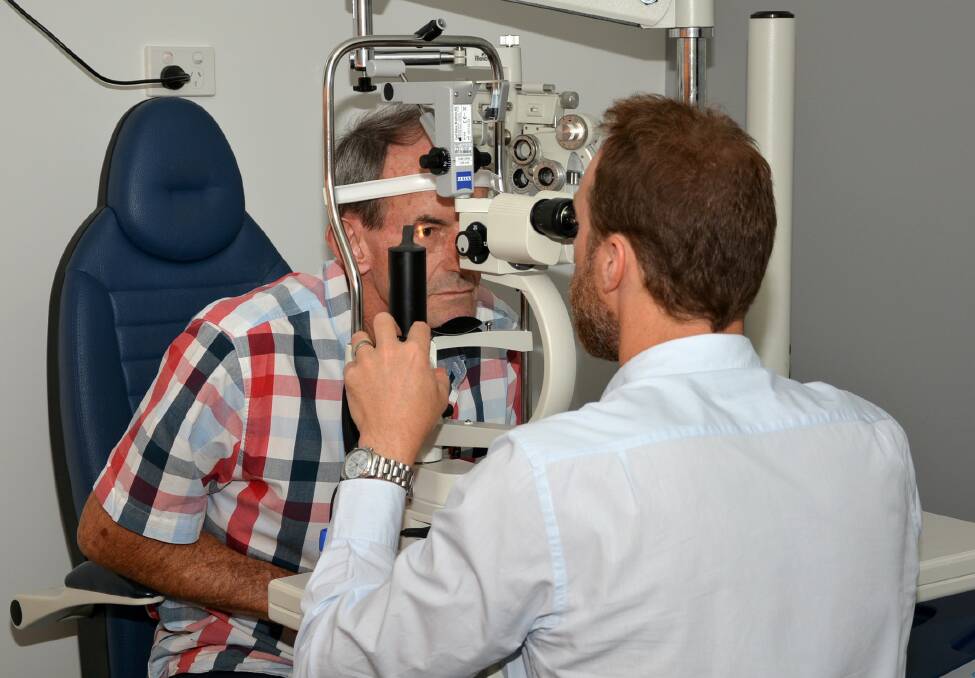 REGULAR CHECK UPS: Optometrist Tony Ireland performs an eye health examination on a patient.