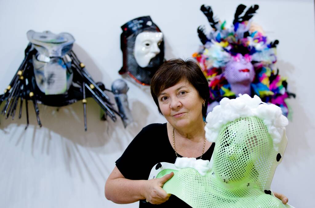 Julie McCrossin with masks used by cancer patients to shield them during radiotherapy to their neck and head and then decorated so they become artistic symbols of their recovery.