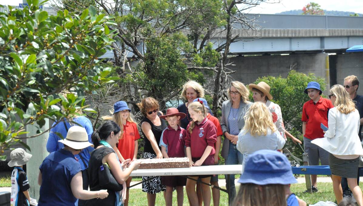 CAPTAIN'S CUT: School captains join hands to make the first cut in the Moruya bridge cake.