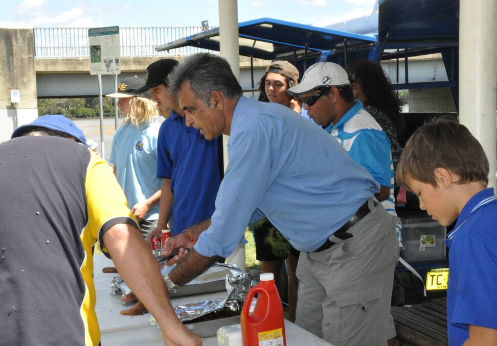 LINE UP: Darryl Cruise, Moruya Public School Aboriginal education officer, is all tongs for the sausage sizzle rush.