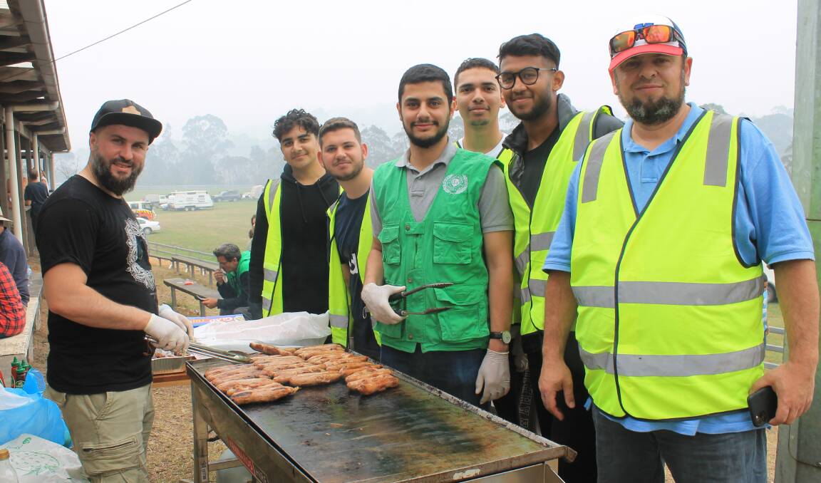 BIG HEARTS: Members of Human Appeal, Australian Islamic Mission and AIM Youth including Omar Al-Jamal (centre) run a barbecue at the Cobargo Showground on Wednesday. Picture: Albert McKnight 
