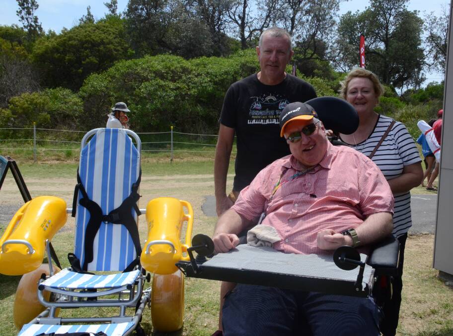 Rod, Greg and Tracey Lee with Broulee surf club's new beach wheelchair.