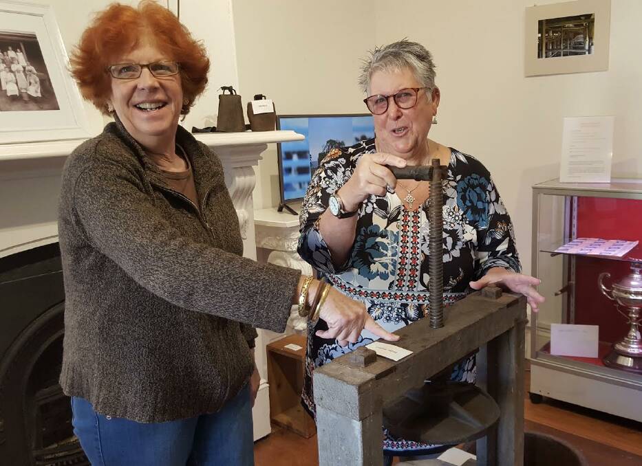 SAY CHEESE: Moruya and District Historical Society's Annie Fitzgerald and Maureen Keating with an artefact on display as part of 'Milk: The River of Life'.