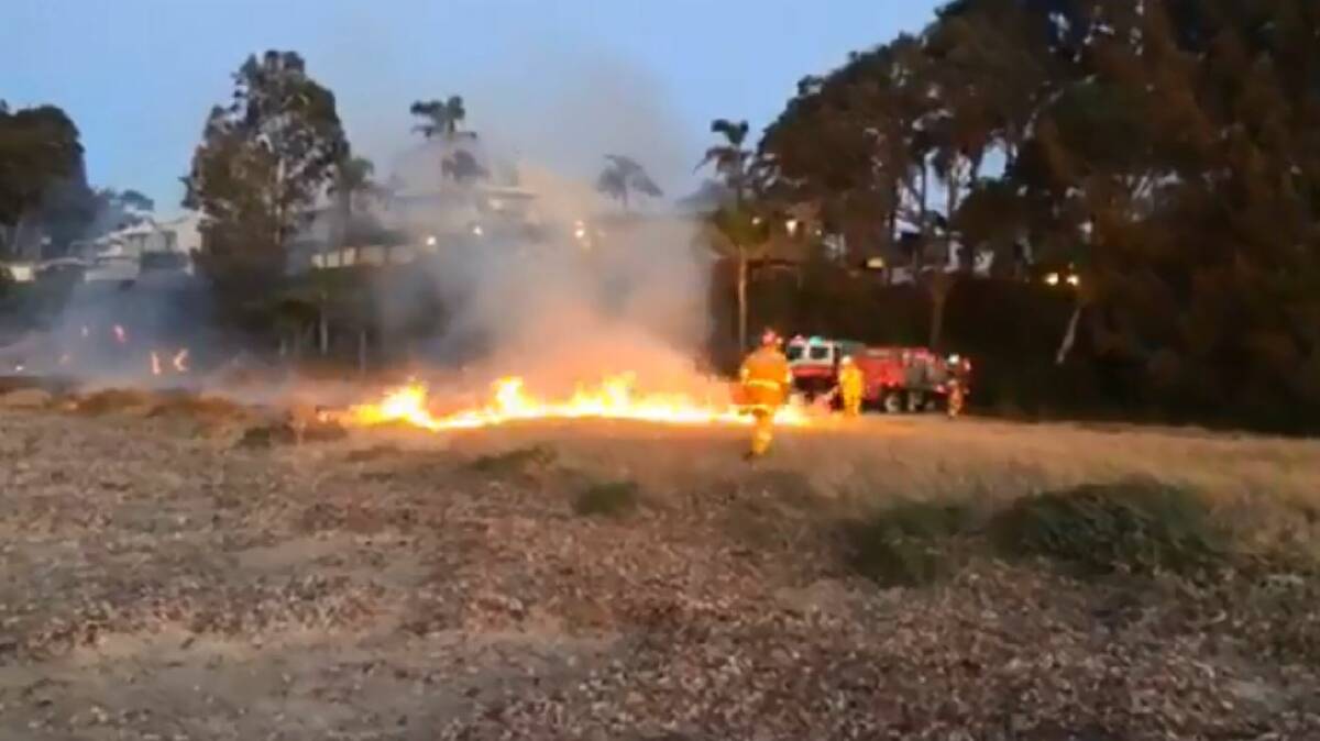 BATEHAVEN BLAZE: Fire crews work to extinguish a grass fire that spread quickly towards properties at the southern end of Corrigans Beach on Wednesday evening.