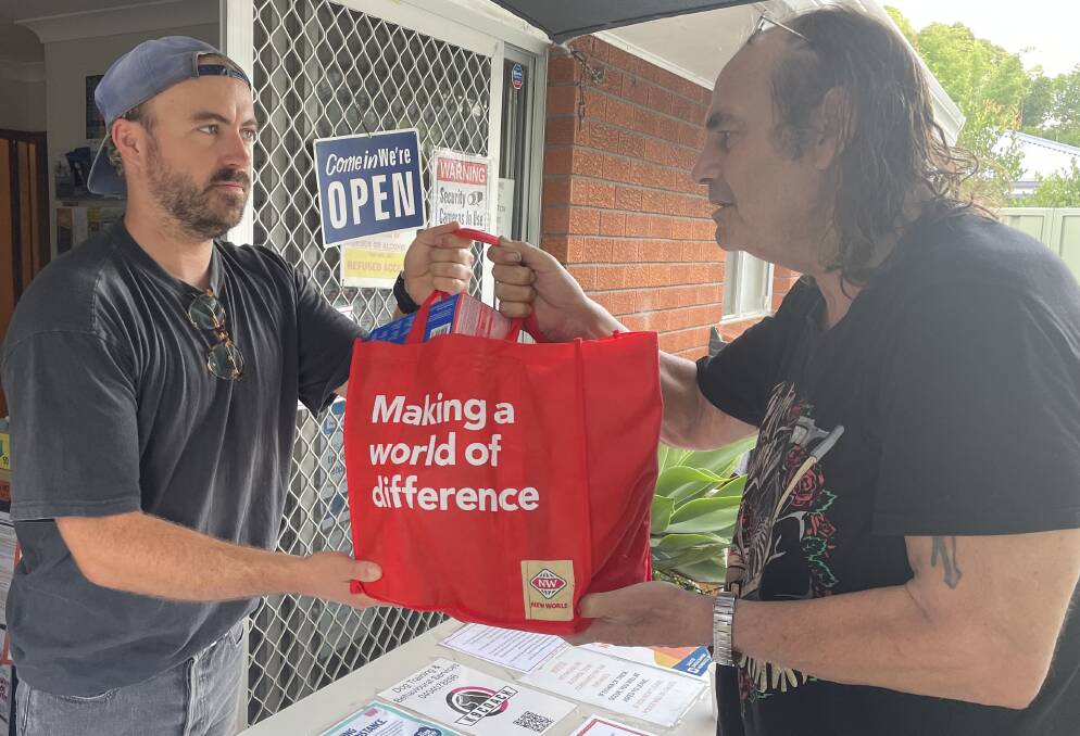 HELP: Shoalhaven Homeless Hub case worker Joey Winkler hands over a bag of food and other essentials to local man Ken Weir, who is living out of his car and a tent. Photo: Robert Crawford