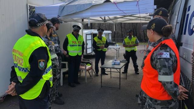 BRIEFING: Officers from across the South Coast Police District and navy personnel at the checkpoint at Timbillica. Photo: Supplied
