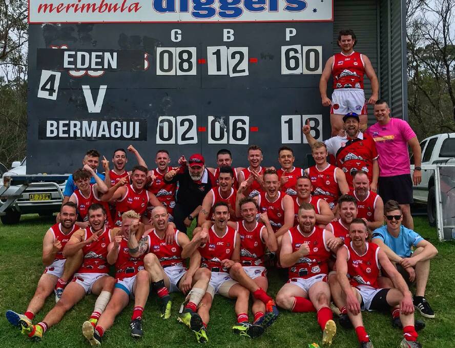 The Eden Whalers celebrating in front of the scoreboard following their grand final win. 