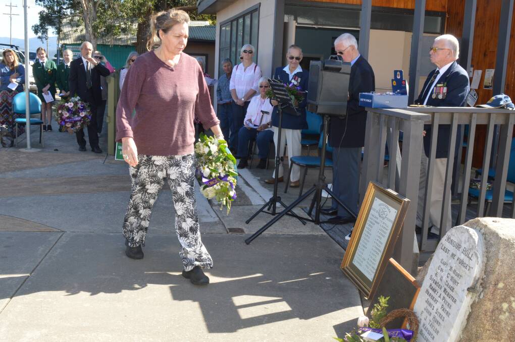 Bodalla business owner Megan Small lays a wreath at the Bodalla War Memorial at the first Anzac Commemoration in the town since 1974.
