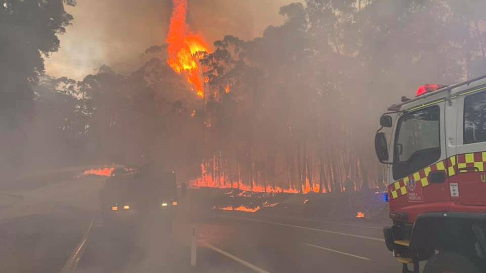 The fire crosses the Kings Highway at Government Bend on Thursday morning. Picture: Fire and Rescue NSW Station 477 Ulladulla. 